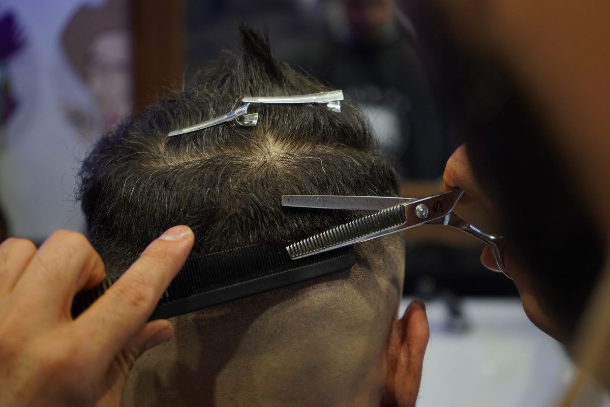 Zdjęcie poglądowe: barber strzyże klienta nożyczkami